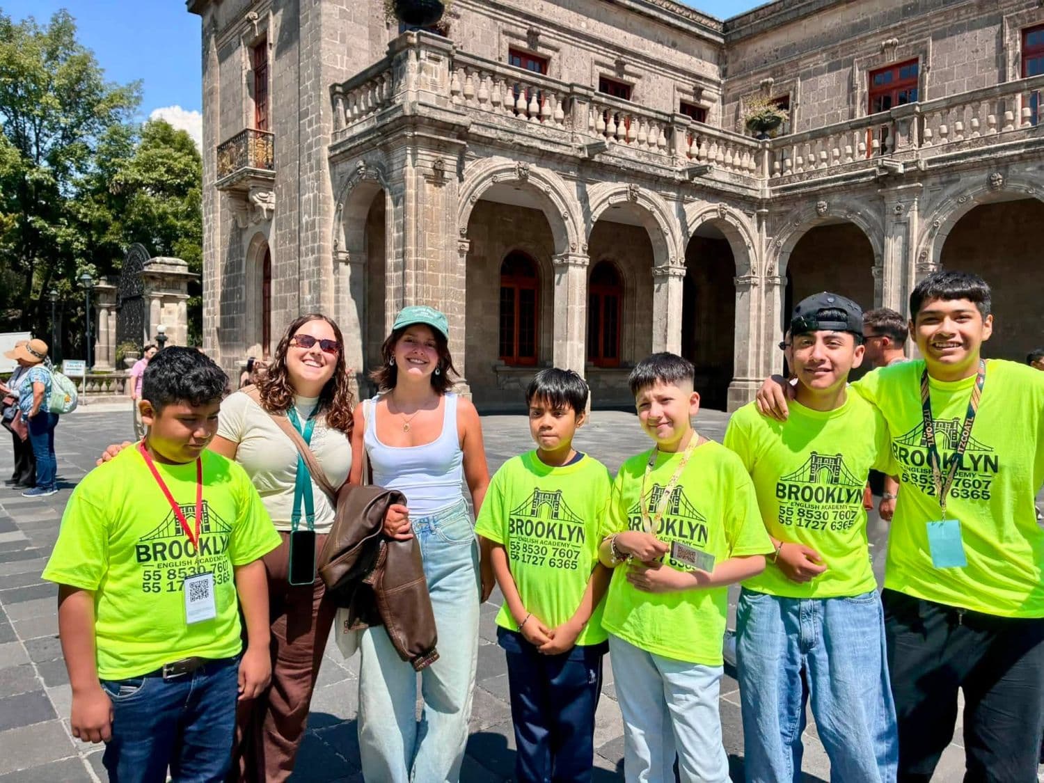 Alumnos de Brooklyn sonriendo junto a dos visitantes extranjeras con quienes practicaron inglés